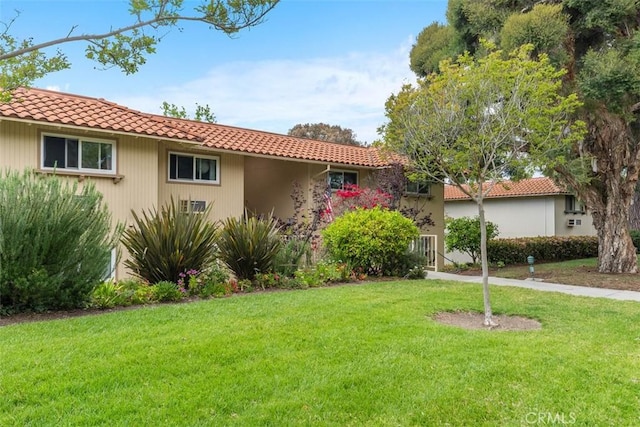 888 Ronda Sevilla Unit D, Laguna Woods, CA 92637 - mediterranean / spanish-style home featuring a tile roof and a front lawn