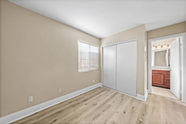 905 E 4th Ave Unit 1, National City, CA 91950 - unfurnished bedroom with light wood-style floors, baseboards, ensuite bathroom, and a closet