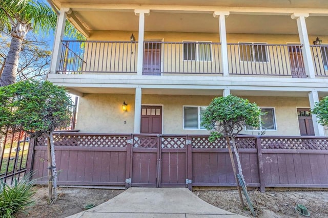 905 E 4th Ave Unit 1, National City, CA 91950 - view of front of house with fence, a balcony, and stucco siding