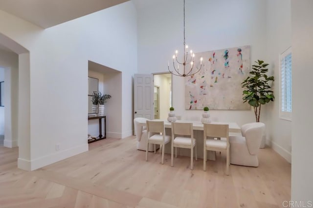 2850 Palmetto Point Ct, Chula Vista, CA 91915 - dining area with a chandelier, a towering ceiling, light wood-type flooring, and arched walkways