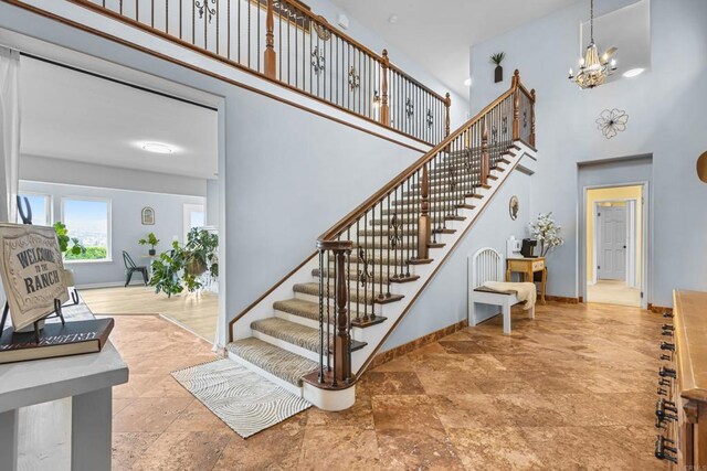 22053 Highland St, Wildomar, CA 92595 - stairs featuring a high ceiling, a chandelier, baseboards, and stone finish floors