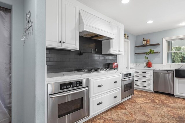 22053 Highland St, Wildomar, CA 92595 - kitchen featuring stainless steel appliances, decorative backsplash, white cabinets, custom range hood, and open shelves