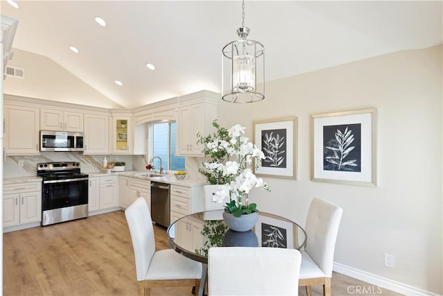 dining space featuring recessed lighting, light wood-style floors, a notable chandelier, visible vents, and lofted ceiling