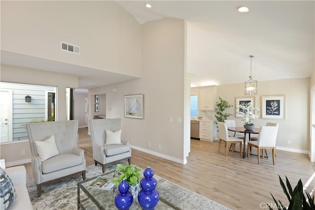 living room featuring recessed lighting, light wood-style floors, baseboards, visible vents, and high vaulted ceiling