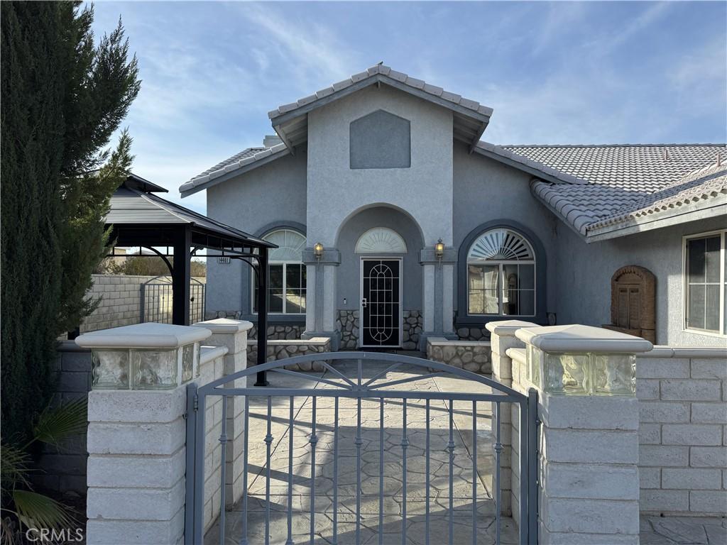 14401 Hurricane Ln, Helendale, CA 92342 - view of front of home featuring a gate, a tile roof, a gazebo, and fence private yard