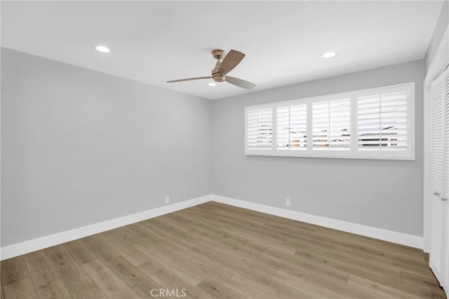 spare room with a ceiling fan, wood finished floors, baseboards, and recessed lighting