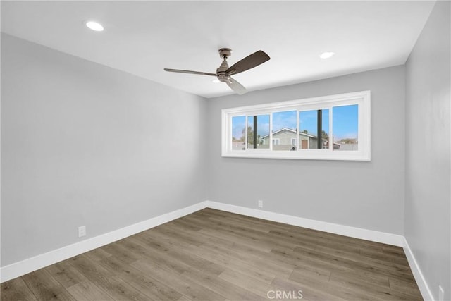 empty room featuring a ceiling fan, wood finished floors, baseboards, and recessed lighting