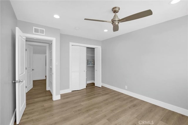 unfurnished bedroom with baseboards, light wood-type flooring, a closet, and recessed lighting
