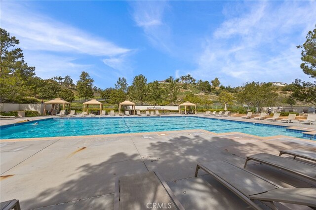 community pool featuring a gazebo, fence, and a patio area