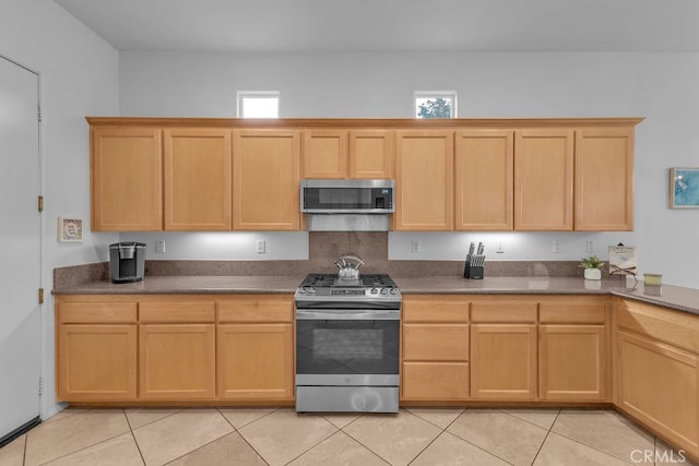 82689 Odlum Dr, Indio, CA 92201 - kitchen featuring stainless steel appliances, light brown cabinets, light tile patterned flooring, and dark countertops