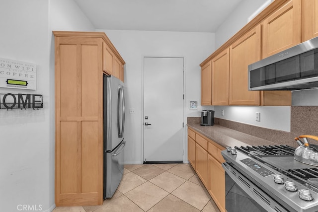 82689 Odlum Dr, Indio, CA 92201 - kitchen with light brown cabinets, dark countertops, stainless steel appliances, and light tile patterned flooring
