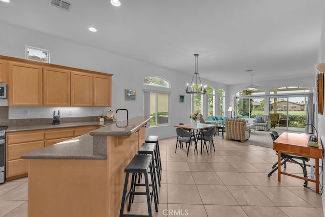 82689 Odlum Dr, Indio, CA 92201 - kitchen with recessed lighting, a breakfast bar, visible vents, light tile patterned flooring, and stainless steel appliances