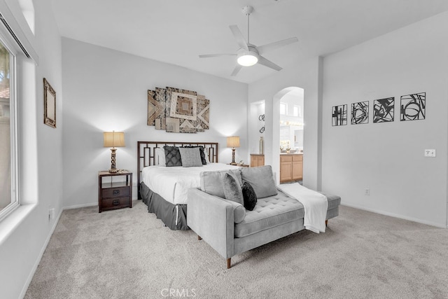 82689 Odlum Dr, Indio, CA 92201 - carpeted bedroom with connected bathroom, arched walkways, baseboards, and a ceiling fan