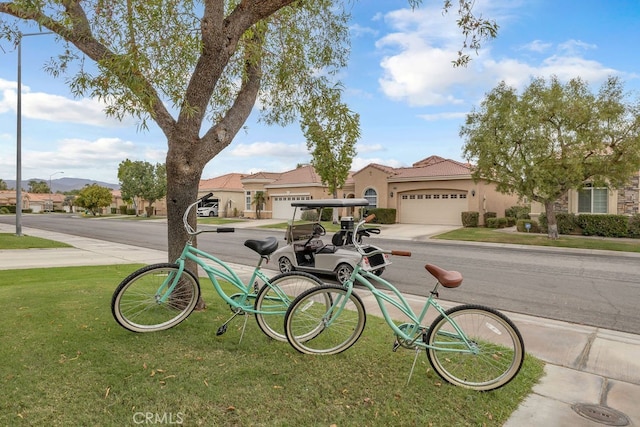 82689 Odlum Dr, Indio, CA 92201 - view of front of property with an attached garage, a tiled roof, stucco siding, a front yard, and driveway