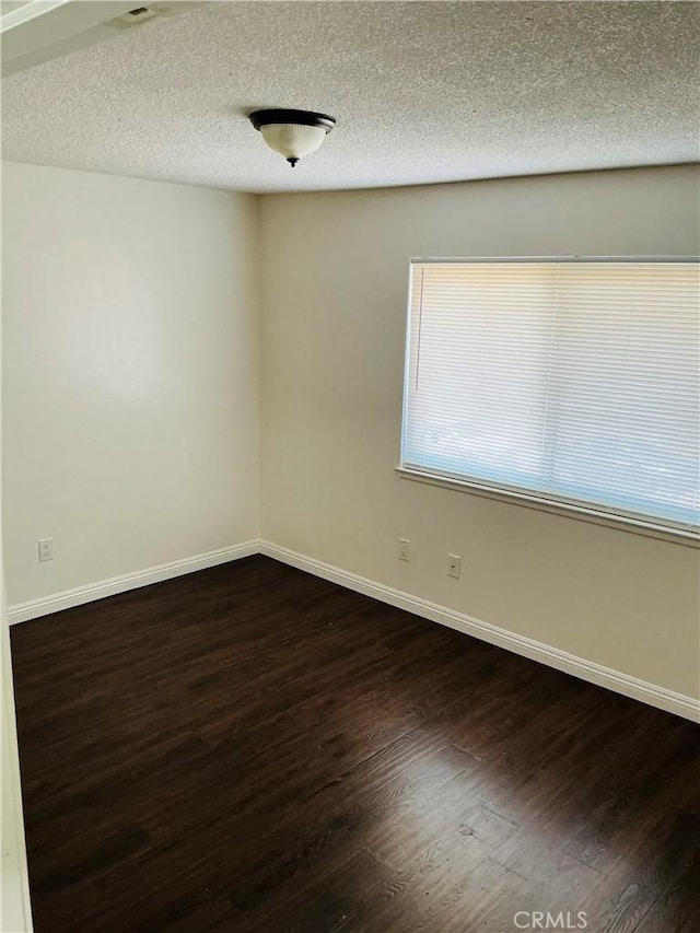3545 20th St, Highland, CA 92346 - empty room with dark wood-style floors, baseboards, and a textured ceiling