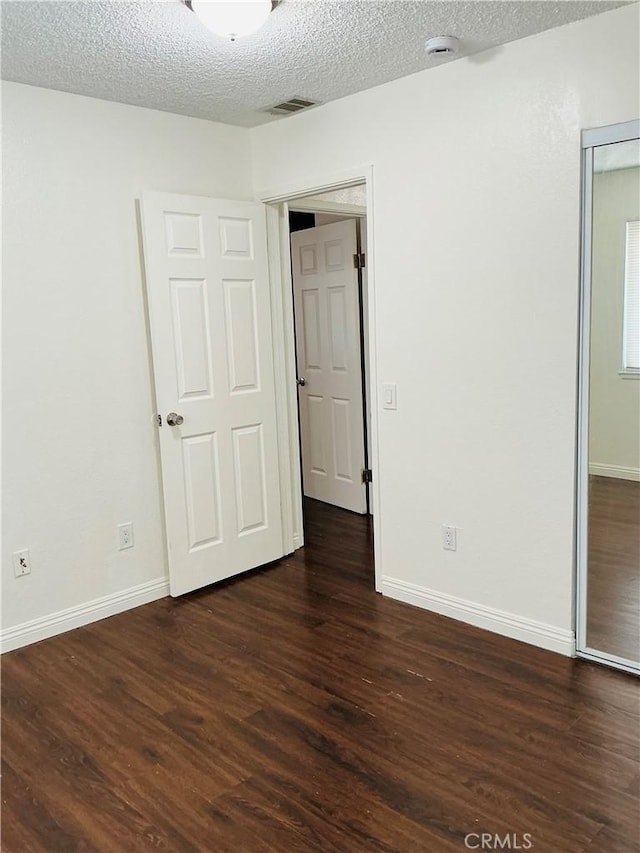 3545 20th St, Highland, CA 92346 - unfurnished bedroom with a textured ceiling, dark wood finished floors, baseboards, and a closet