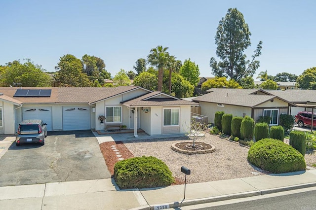 1398 Panorama Ridge Rd, Oceanside, CA 92056 - ranch-style home with a garage, driveway, roof mounted solar panels, stucco siding, and a shingled roof