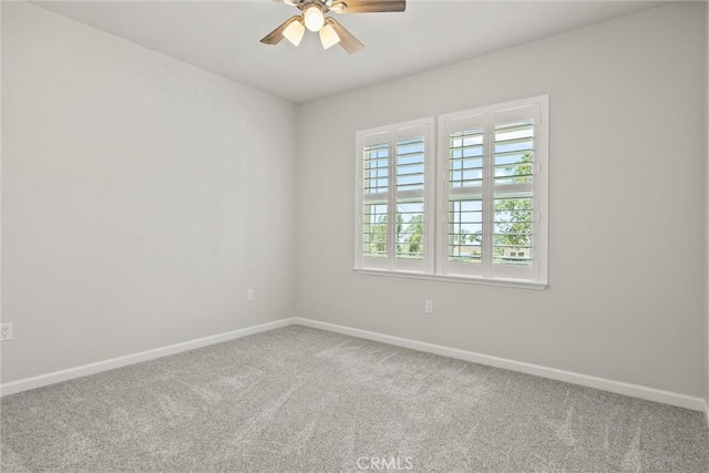 carpeted empty room with ceiling fan and baseboards
