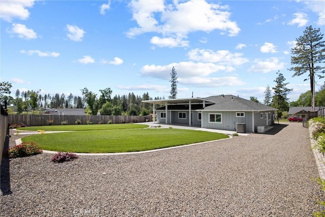 back of property with fence, a lawn, and a patio