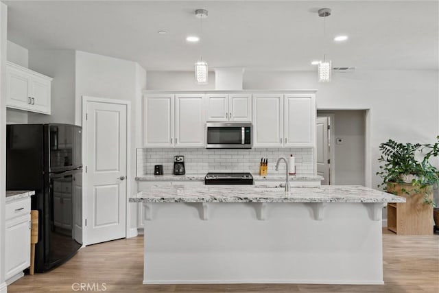 6294 W Wagstaff Rd, Paradise, CA 95969 - kitchen featuring stainless steel appliances, light wood-type flooring, white cabinetry, backsplash, and light stone counters