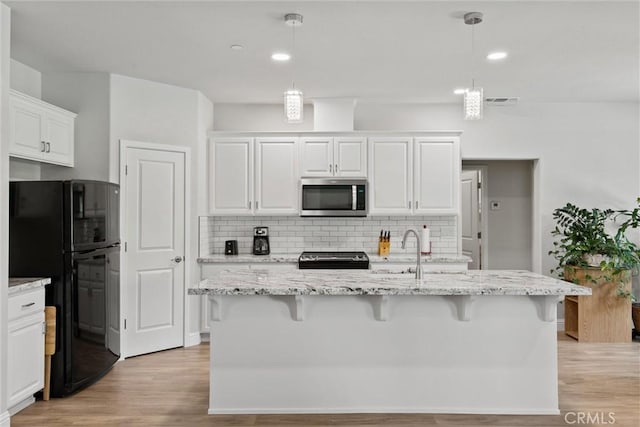 6294 W Wagstaff Rd, Paradise, CA 95969 - kitchen featuring stainless steel microwave, freestanding refrigerator, light wood-style flooring, range, and recessed lighting