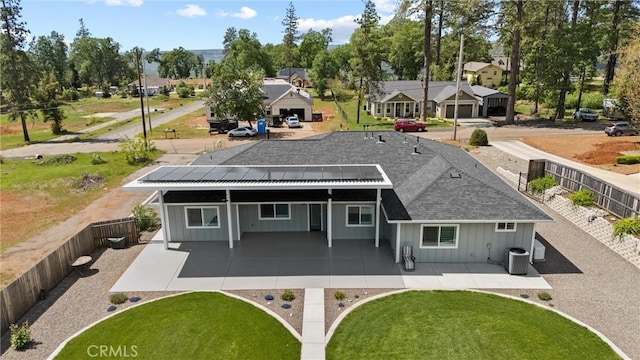 back of property featuring cooling unit, a residential view, board and batten siding, and a fenced backyard