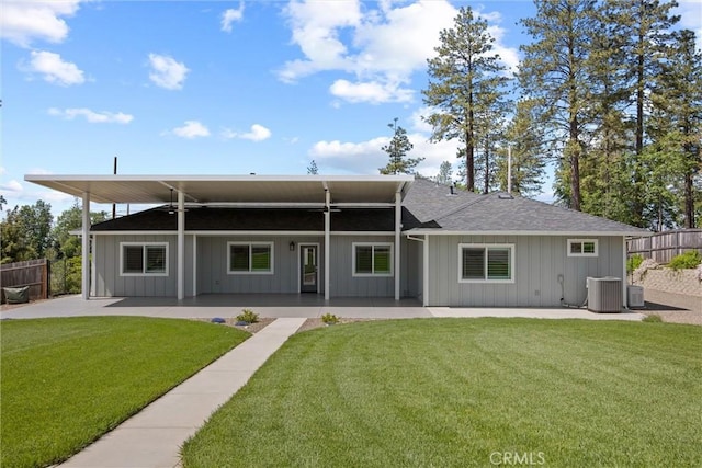 back of property featuring central AC, a patio area, a shingled roof, fence, and a yard