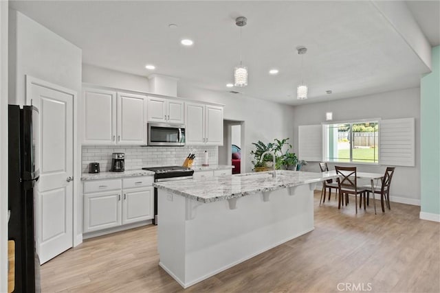 6294 W Wagstaff Rd, Paradise, CA 95969 - kitchen with stainless steel appliances, backsplash, light stone countertops, white cabinets, and recessed lighting