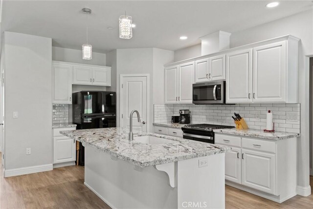 kitchen with white cabinets, tasteful backsplash, appliances with stainless steel finishes, and a sink