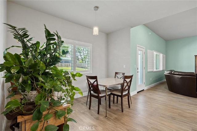 dining space featuring baseboards and light wood-style floors