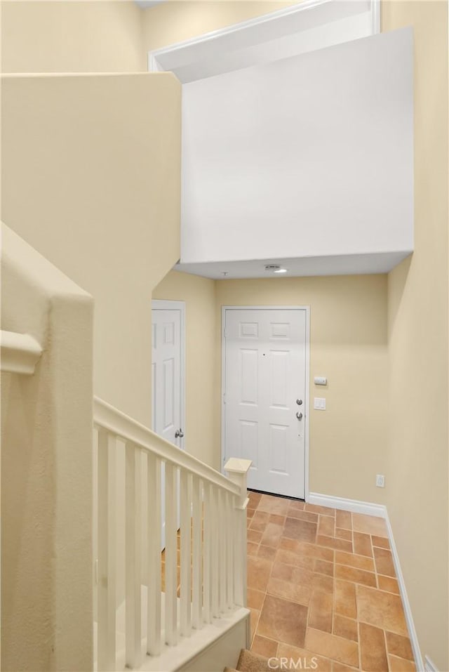 foyer entrance with stone finish flooring and baseboards