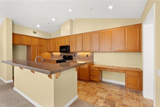kitchen featuring tasteful backsplash, tile countertops, black appliances, brown cabinets, and visible vents
