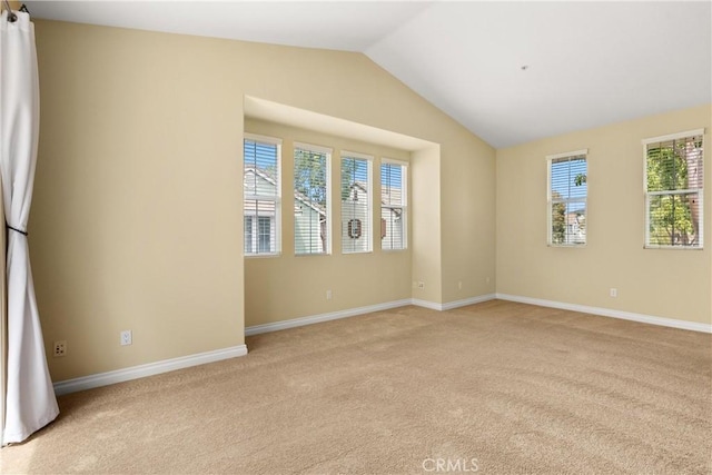 spare room with lofted ceiling, baseboards, and light carpet