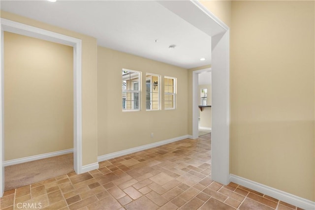 empty room featuring baseboards and recessed lighting