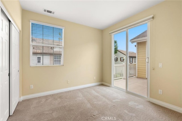 unfurnished bedroom with carpet, visible vents, baseboards, and access to outside