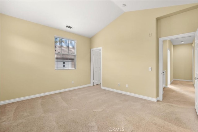 unfurnished bedroom with vaulted ceiling, visible vents, baseboards, and light carpet