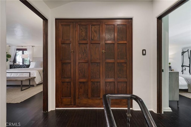 entryway with dark wood finished floors and baseboards