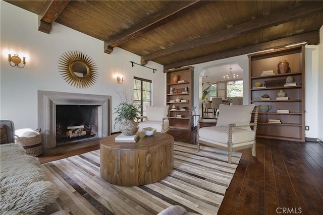 living room featuring beamed ceiling, hardwood / wood-style floors, wood ceiling, and an inviting chandelier