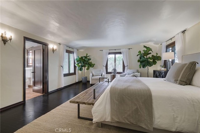 bedroom with baseboards and wood finished floors