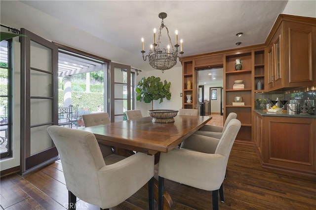 dining area with dark wood finished floors and an inviting chandelier
