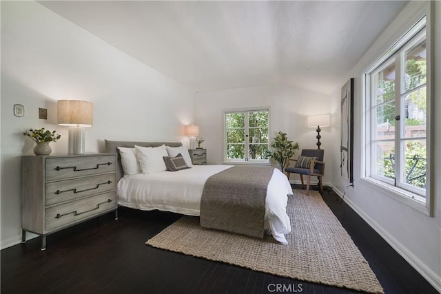 bedroom featuring dark wood finished floors, vaulted ceiling, and baseboards