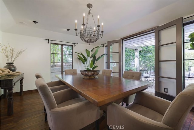 dining area featuring baseboards, a chandelier, and dark wood-type flooring