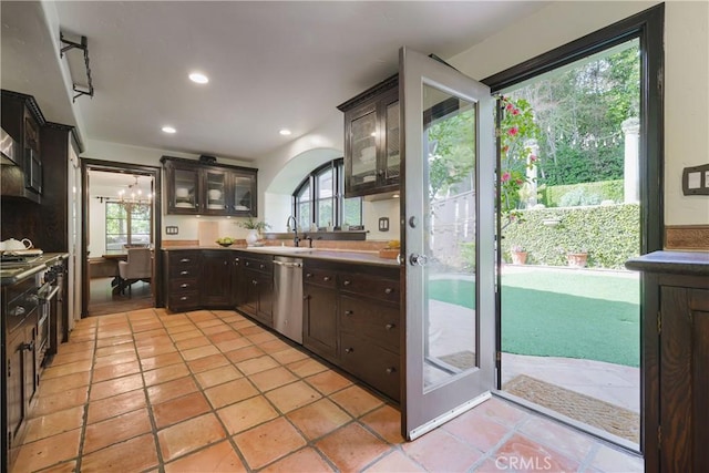 kitchen featuring dark brown cabinetry, dishwasher, a sink, and a healthy amount of sunlight