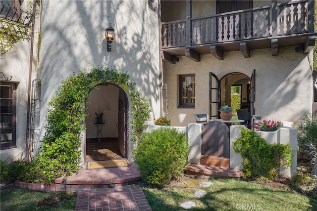doorway to property featuring stucco siding and a balcony