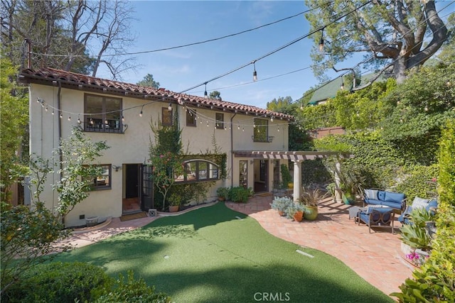 back of property with a tile roof, a pergola, a patio area, outdoor lounge area, and stucco siding