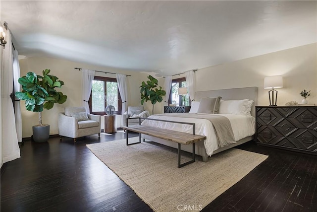 bedroom with wood finished floors and multiple windows
