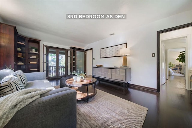 living area with visible vents, baseboards, and wood finished floors