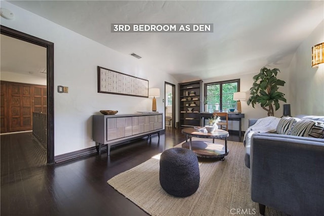 living room with visible vents, baseboards, wood finished floors, and built in shelves
