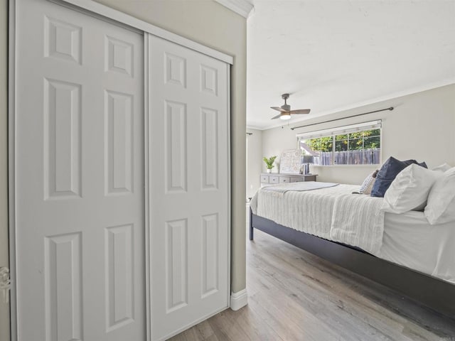 bedroom featuring wood finished floors, a ceiling fan, and ornamental molding