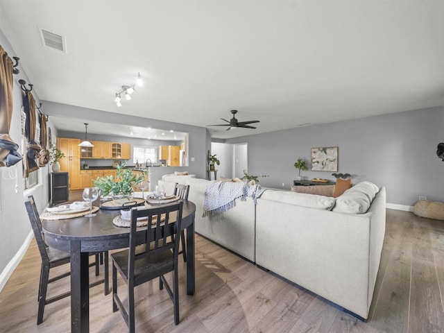 dining room with ceiling fan, baseboards, light wood-style floors, and visible vents